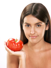 Joven mujer hispana sujetando un tomate fresco.