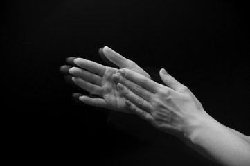 Female hands clapping on black, side-view