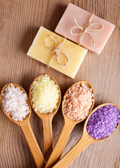 Various types of spa sea salt and soap in wooden spoons closeup