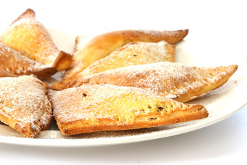 Sweet baked pastry triangles on white plate