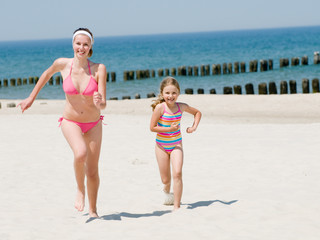 Naklejka premium Happy summer vacation - girls playing on the beach