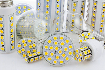 various bulbs with 3-chip SMD LEDs next to tungsten bulb