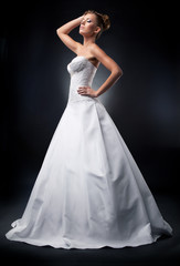 Fototapeta na wymiar Fashion model attractive bride standing in wedding dress