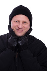 Mann mit Handschuhen und Mütze lächelt