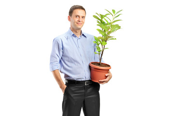 A smiling man holding a pot with decoration plant