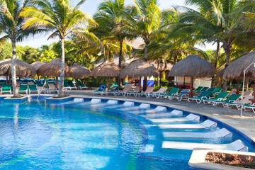 Tropical swimming pool with sunbeds in Mexico