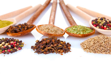 spices in the spoons isolated on white