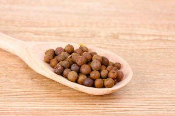 pepper spice on the spoon on wooden background