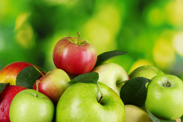 A lot of fresh organic apples on wooden table outside
