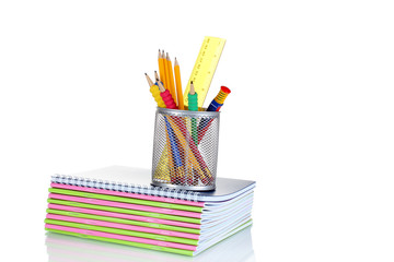 Fototapeta premium Pencils in holder and notebooks isolated on white