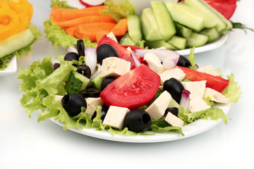 Greek salad on plate and sliced вЂ‹вЂ‹vegetables closeup