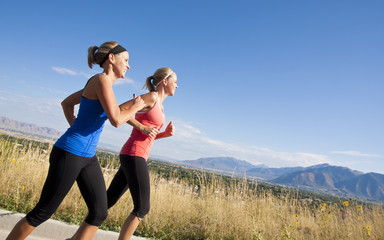 Side view of Two Female joggers running outdoors