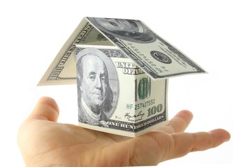 A money house sitting in hand isolated on a white background