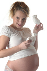 Frau schwanger hält babyschuhe