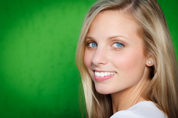 hübsche blonde junge frau vor grünem hintergrund