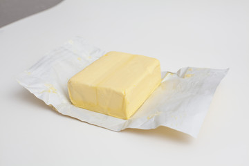 big piece of butter on a white package paper
