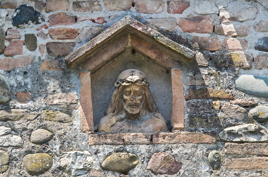 Stone Christ in a wall niche.
