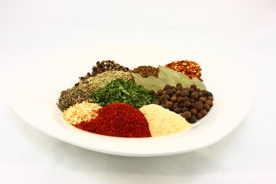 White Plate Filled With Dried Herbs And Spices