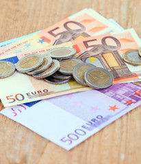 Image of euro currency: coins and banknotes on wooden surface