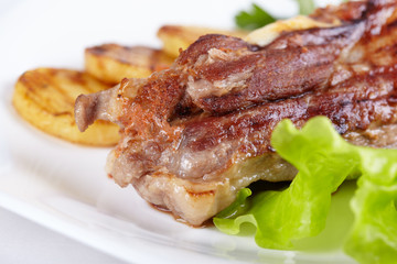 Grilled meat with vegetables on white plate