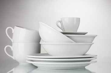 empty bowls, plates and cups on gray background
