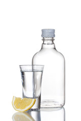 Bottle of vodka and wineglass with lemon isolated on white