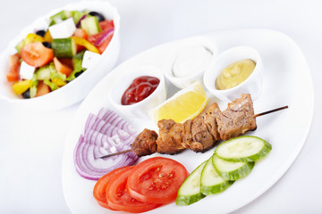 Kebab with fresh vegetables and greek salad