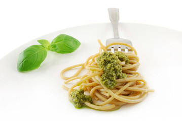 Vollkorn-Spaghetti mit Pesto auf weißem Teller