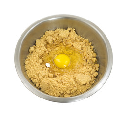 Cookie dough in bowl with broken egg shell