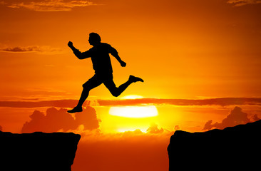 Man jump through the gap between the cliff