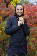 Portrait of  attractive young brunette at bright autumn bush