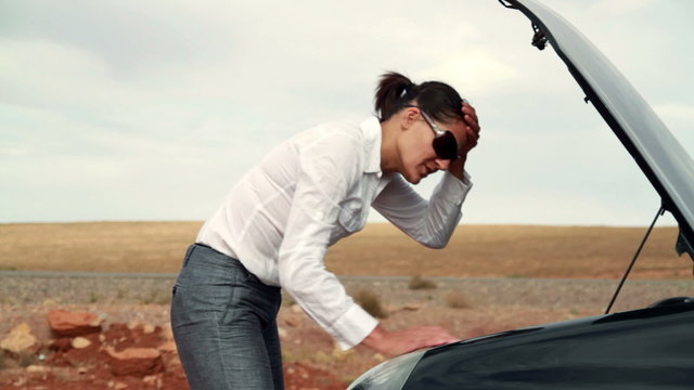 Upset businesswoman by the broken car, outdoors