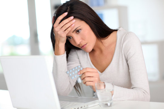 Woman with headache in front of laptop computer