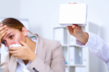 Woman in office holding a pack of medicine