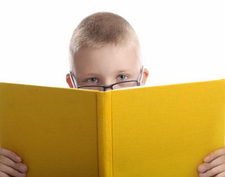 boy looking from behind a book