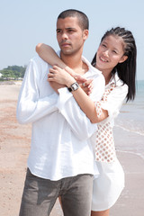 african man and asian woman lover on the beach