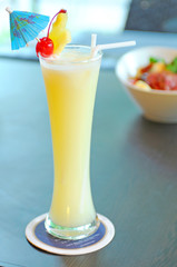 Yellow alcohol cocktail with pineapple, lemon