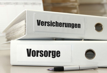 Versicherungsunterlagen in weißen Aktenordnern