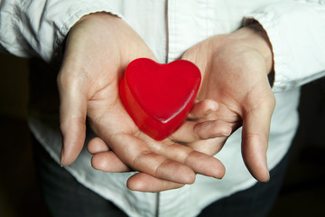 man holding a red heart in hands