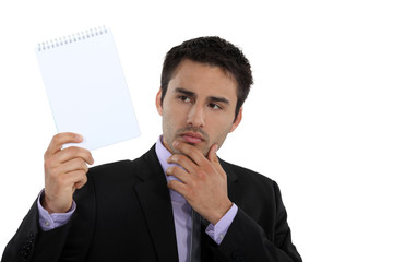 Businessman holding up a blank notepad