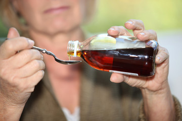 Woman taking cough medicine