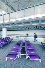 row of purple chair at airport with moving traveler in Hongkong