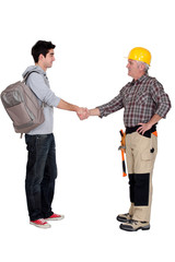 Old and young student worker shaking hands