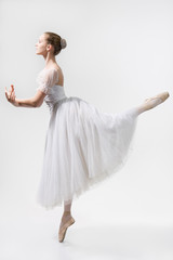 Beautiful ballerina dances in a white dress - obrazy, fototapety, plakaty