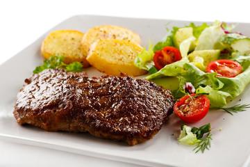 Grilled beefsteak, baked potatoes and vegetables