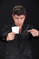 Portrait of man with blank card isolated on black background.