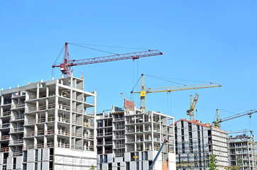 Crane and building construction site against blue sky