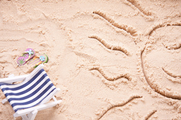 Fototapeta na wymiar Smiling sun drawn on a sandy beach