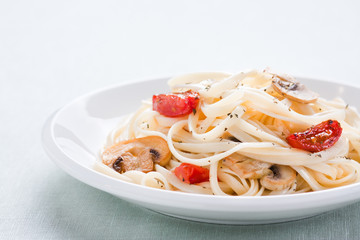 Tagliatelle sautéed with tomatoes and mushrooms