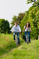 Fototapeta premium Man and woman cycling in summer
